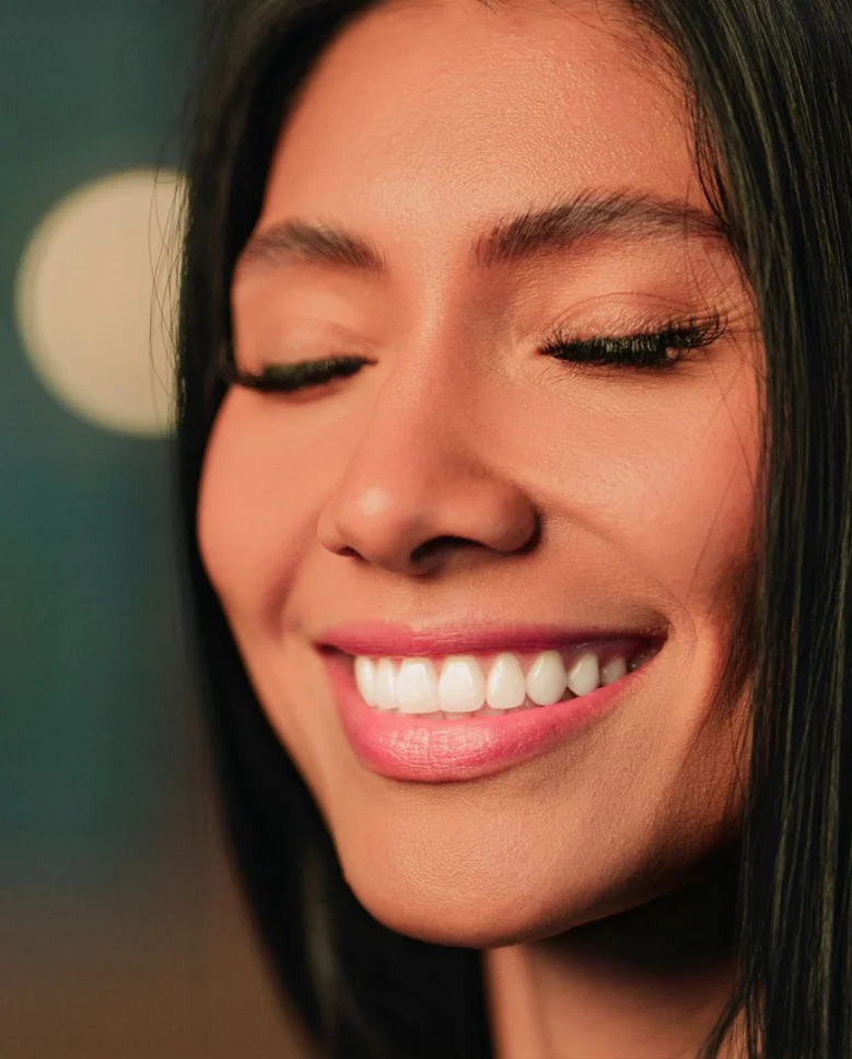 Woman with eyes closed and smooth wrinkle-free forehead smiling