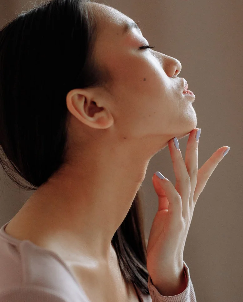 Woman tilting her head back and touching her chin